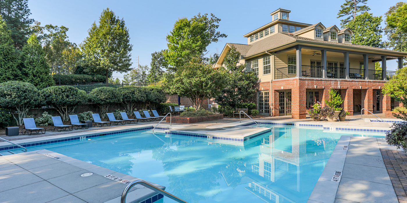 Outside picture of pool deck with clubhouse in backgroup