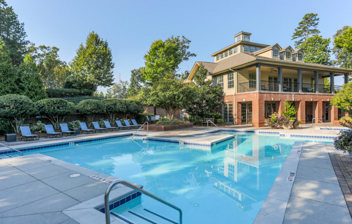 Outside picture of pool deck with clubhouse in backgroup