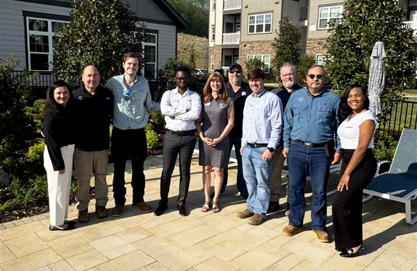 10 people standing together in front of a building