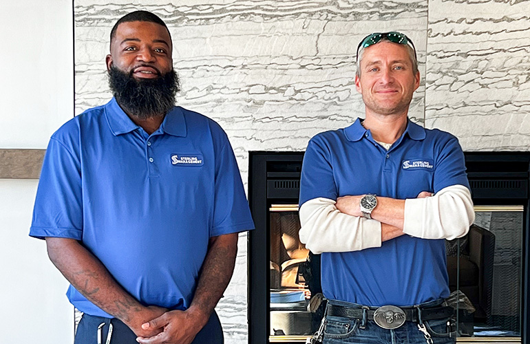 2 men standing in front of fireplace